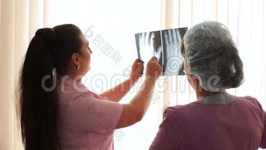 女医生在看x光片并讨论x光片。